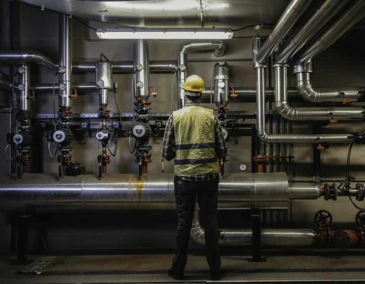 technicien de Groupe E qui entretient une installation de chauffage