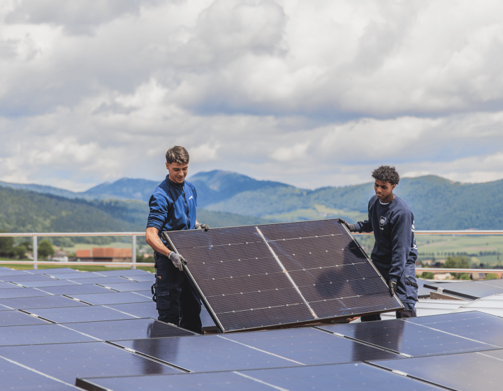 Deux collaborateurs de Groupe E installent des panneaux solaires