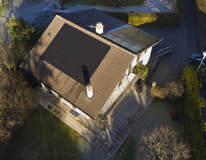 Luftaufnahme eines Hauses mit einer Photovoltaikanlage von Groupe E