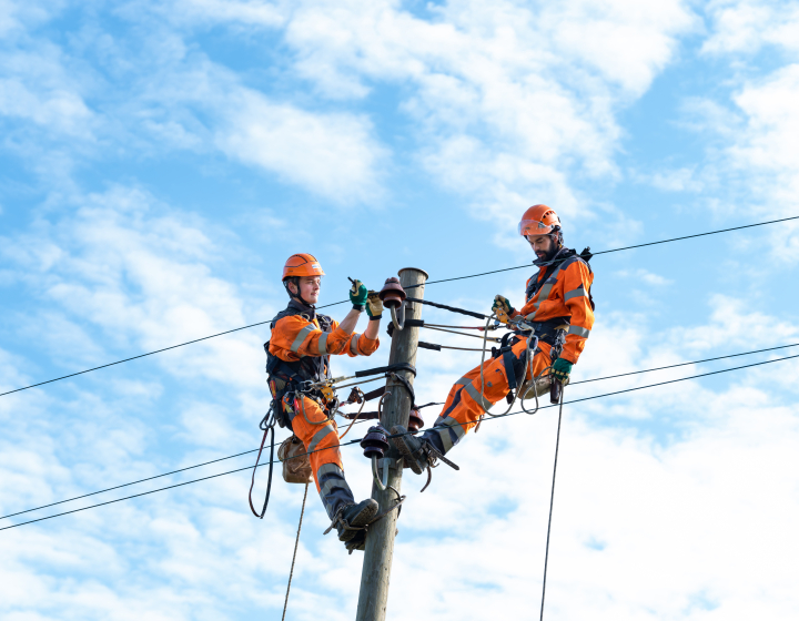 Photo de deux collaborateurs de Groupe E faisant une intervention sur le réseau électrique
