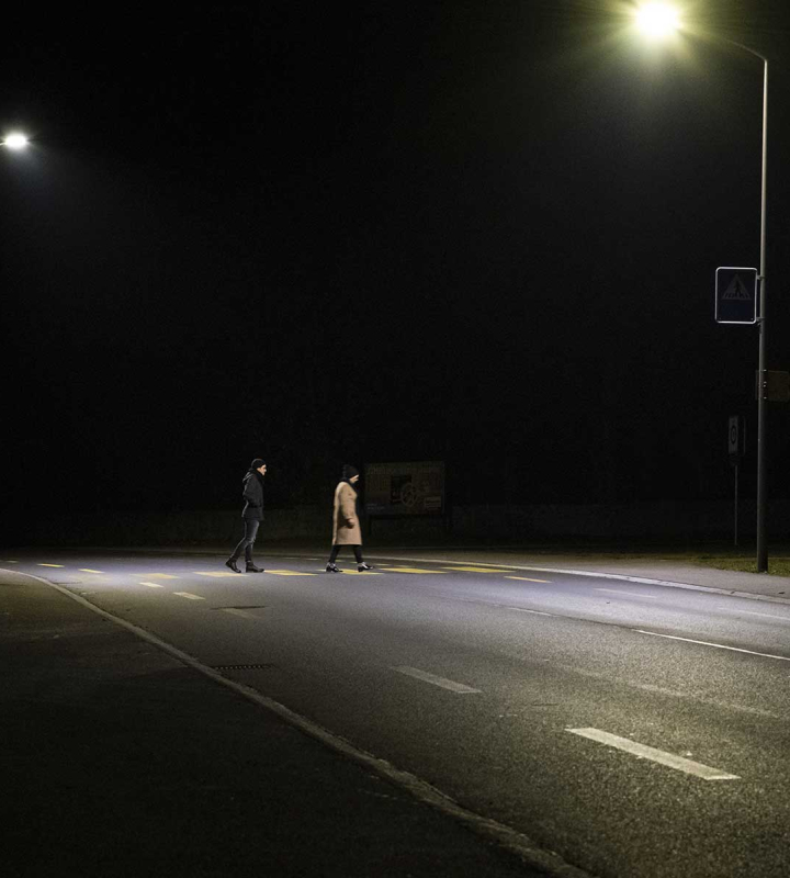 Personnes traversant un passage piéton de nuit