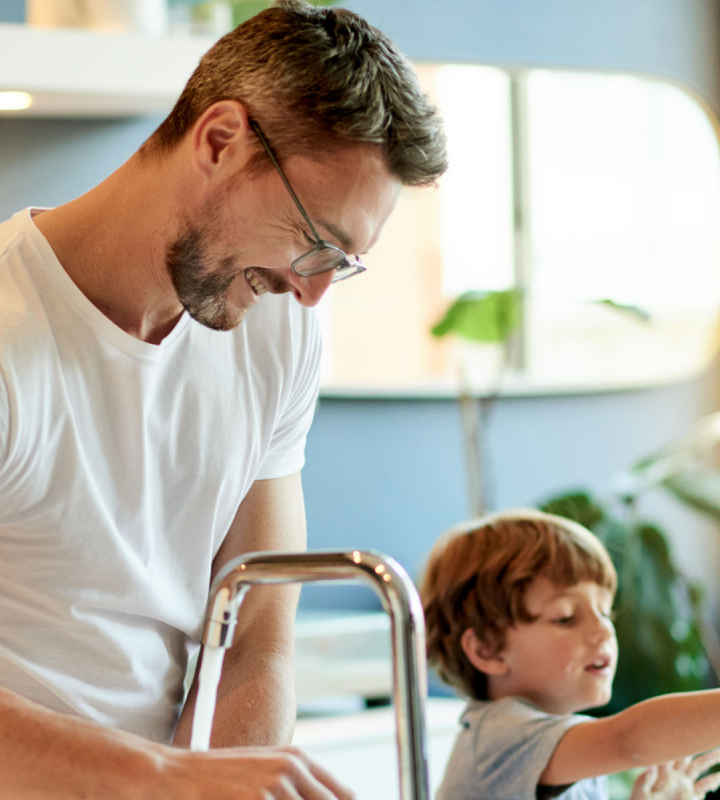 Un père avec son fils dans une maison chauffée par Groupe E