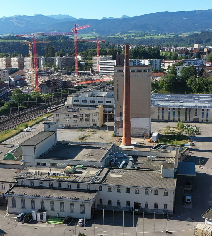 vue aérienne d’un site industriel et urbain illustrant Neuronis, la solution de gestion intelligente des énergies proposée par Groupe E pour les professionnels
