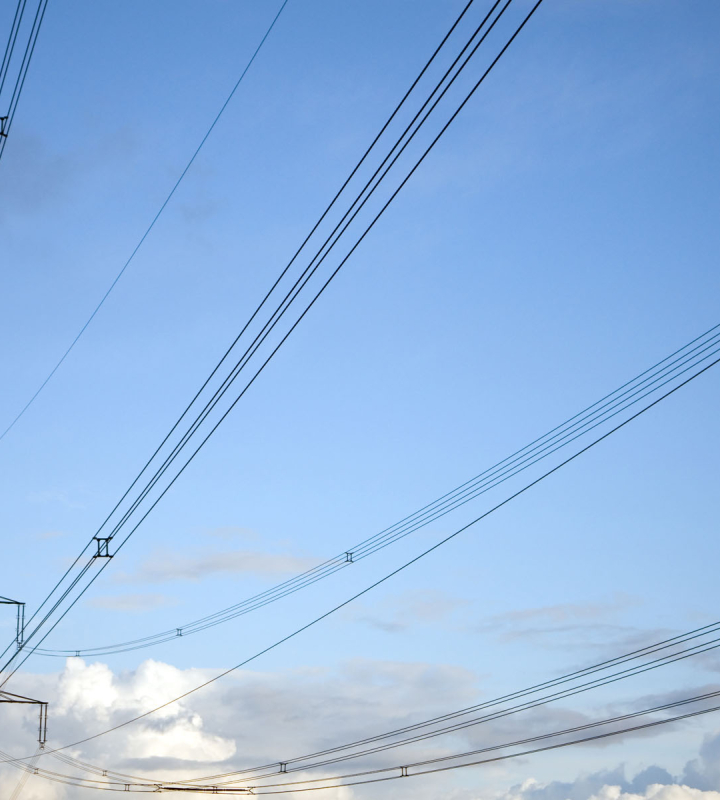 Photo d'une ligne à haute tension, sur fond de ciel bleu