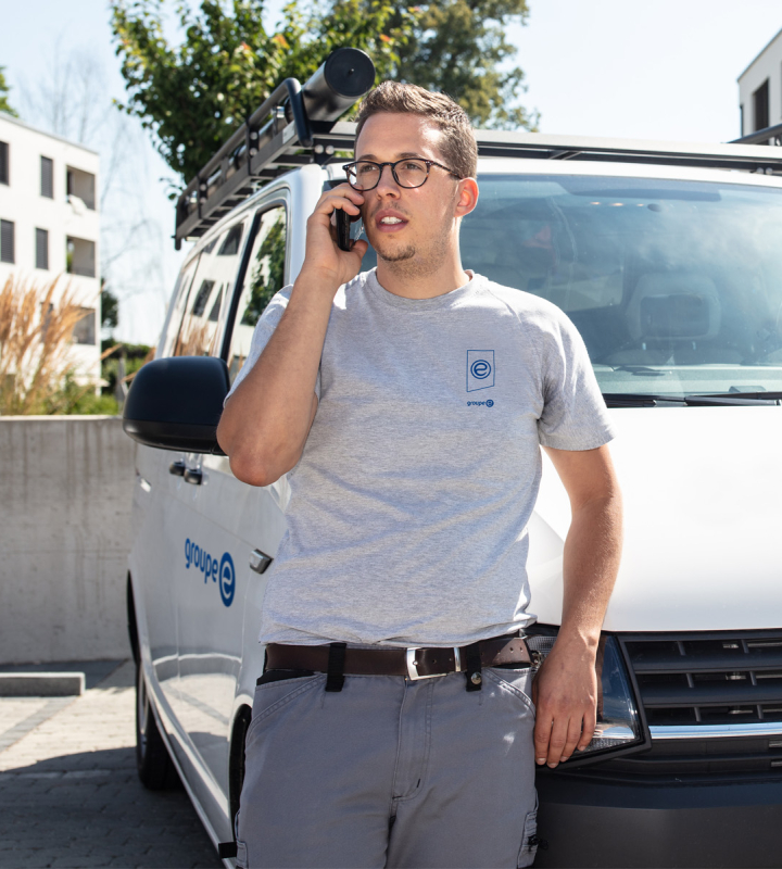 Un dépanneur de Groupe E est en conversation téléphonique avec un client