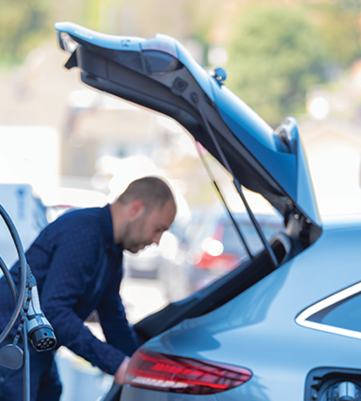 un homme devant le coffre ouvert de sa voiture