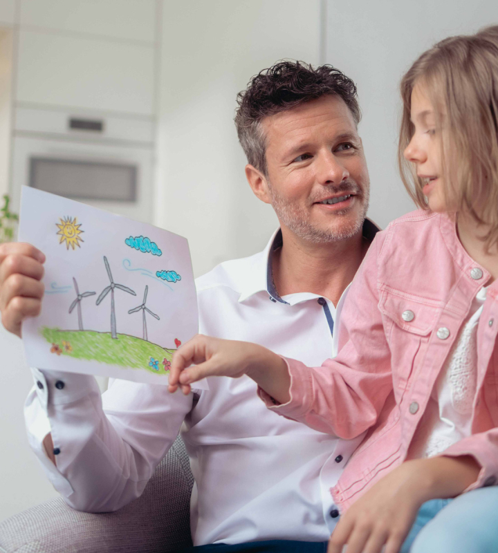 Un papa et sa fille regardent un dessin