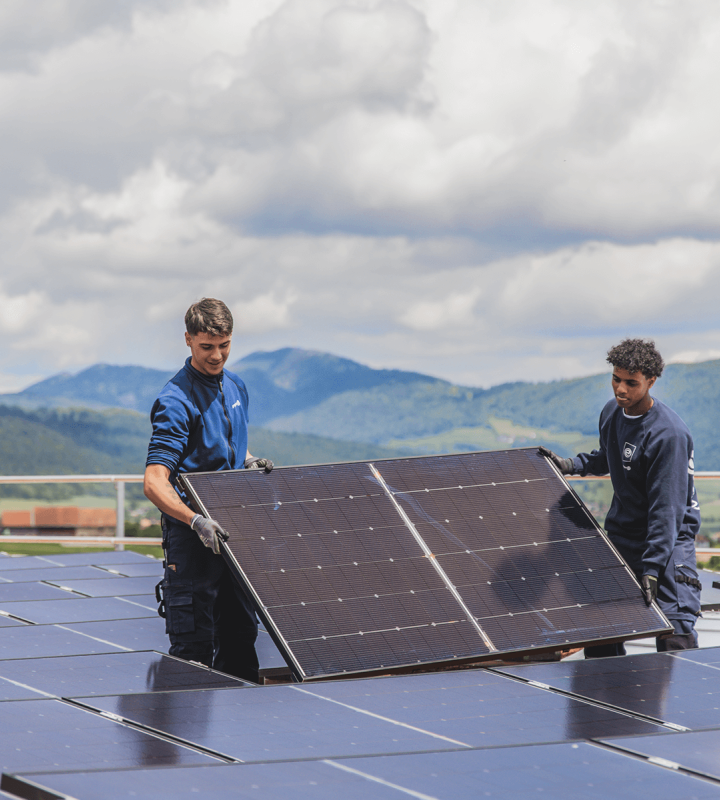 Deux collaborateurs de Groupe E installent des panneaux solaires