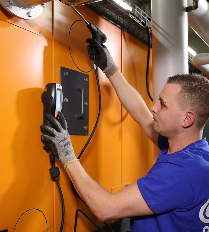 Un collaborateur de Groupe E effectue la maintenance préventive d'une centrale de chauffe