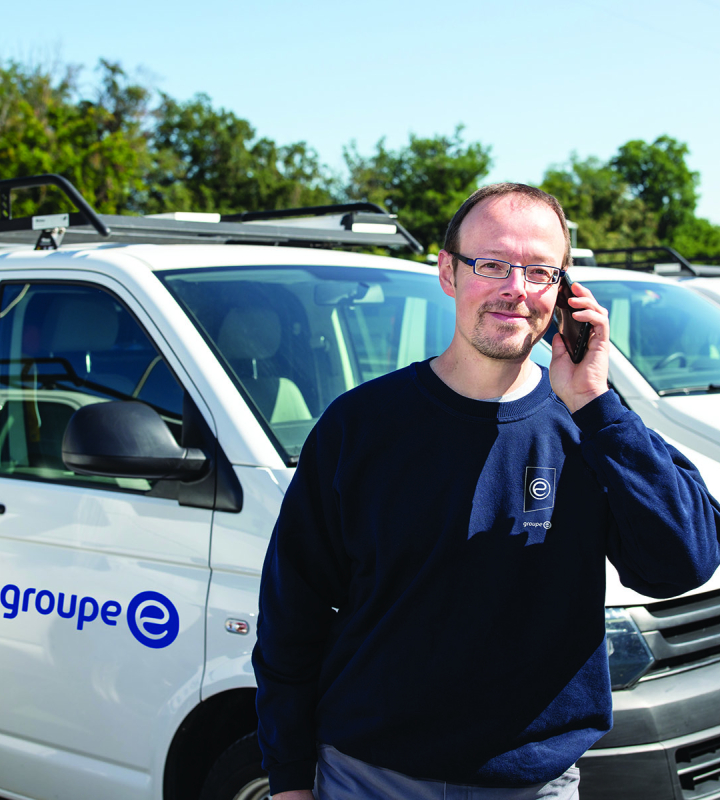 Un technicien de Groupe E en conversation téléphonique avec un client