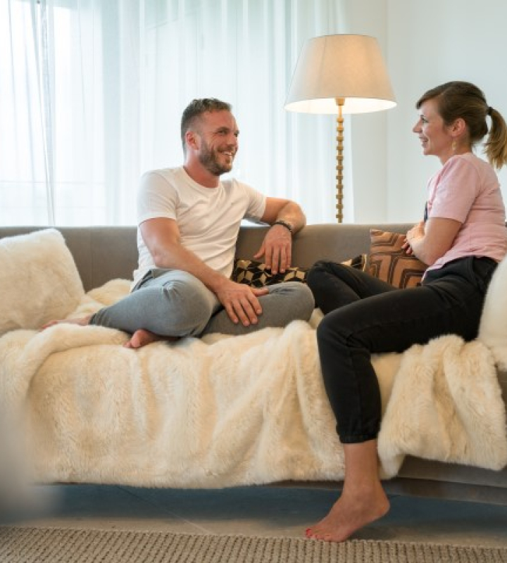 un couple assis sur un canapé à pieds nus