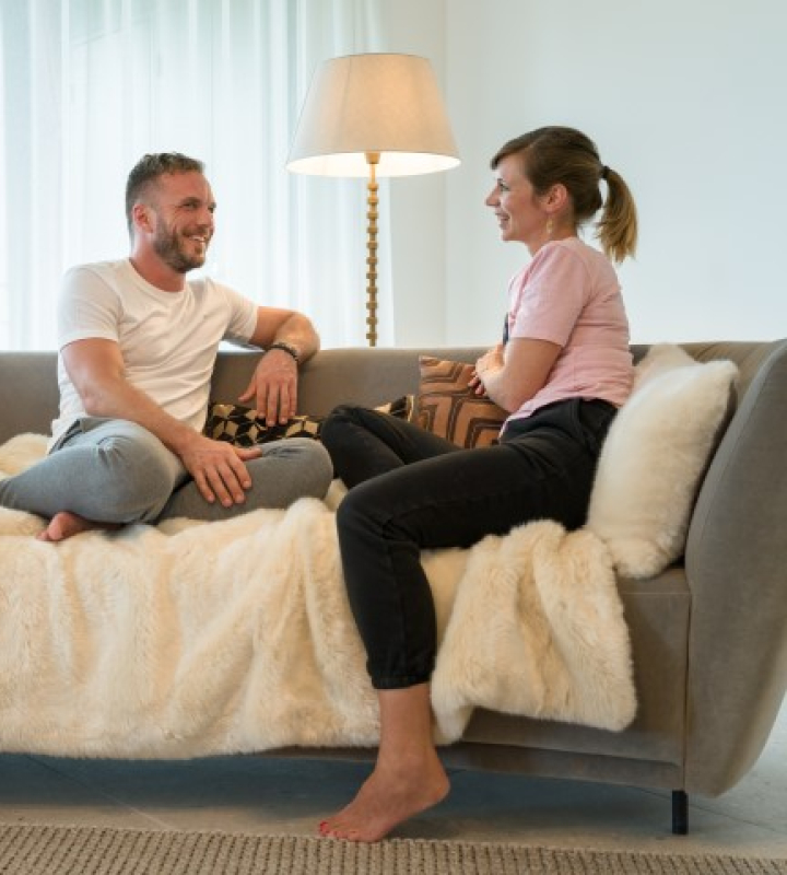 ein Paar, das mit nackten Füßen auf einem Sofa sitzt