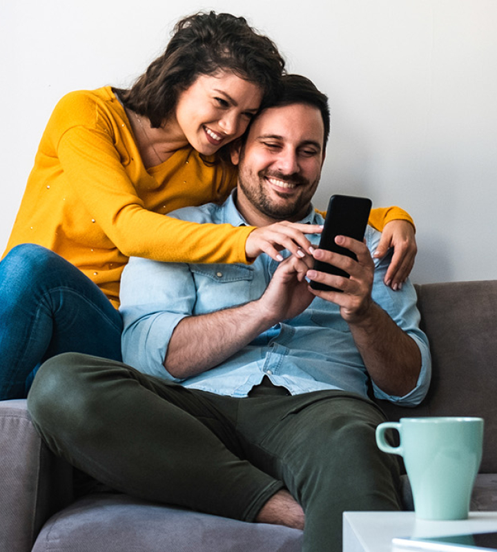 Un couple consulte son taux d'autoconsommation sur un smartphone