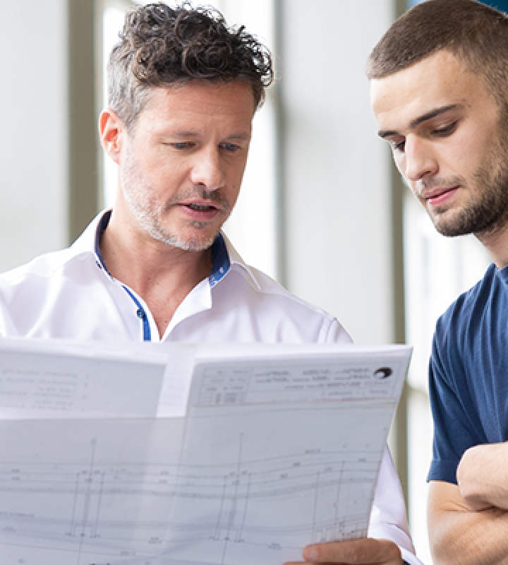 Drei Mitarbeiter der Groupe E tauschen sich über einen Plan aus