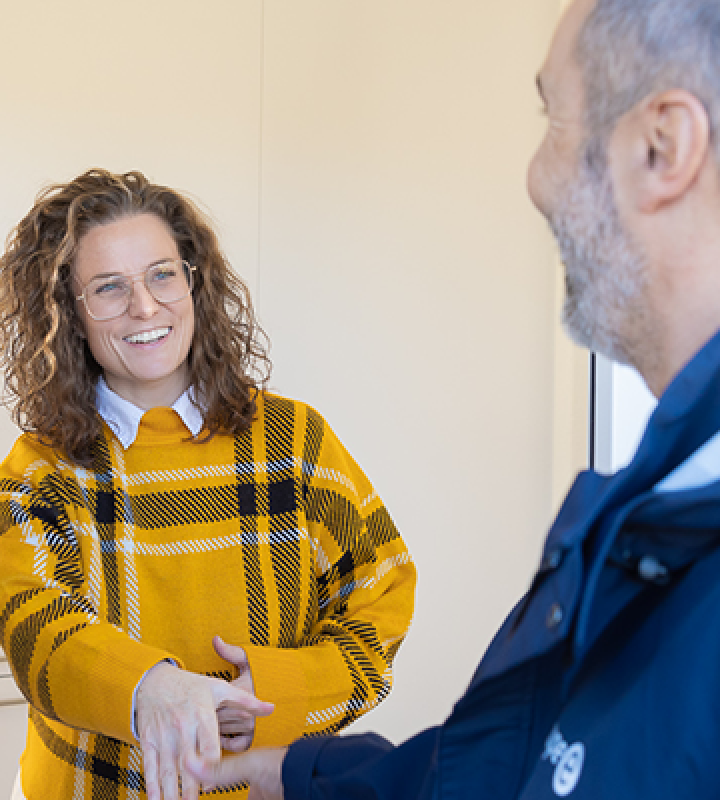 Un collaborateur de Groupe E, sur la pas de porte d'un couple de clients. 