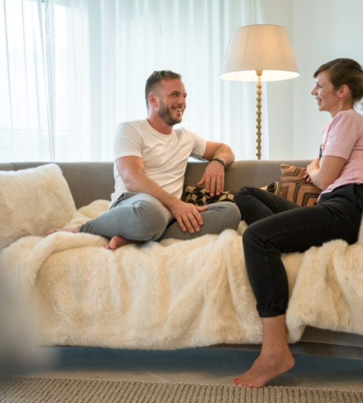 Un couple assis sur un canapé les pieds nus
