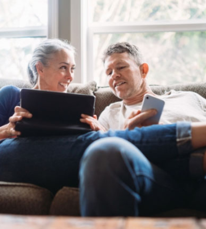 couple heureux qui consulte leur facture du chauffage à distance de Groupe E