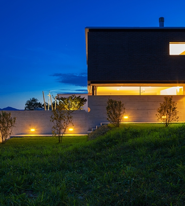 Une villa de nuit, avec les lumières allumées, consommant sa propre production d'électricité