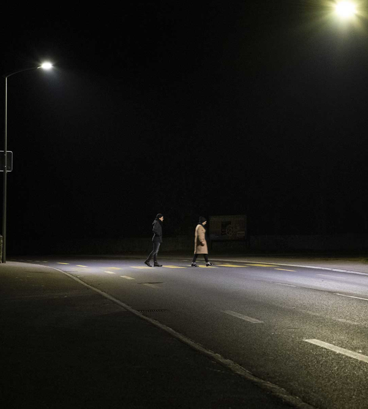 Deux personnes traversant un passage piéton de nuit