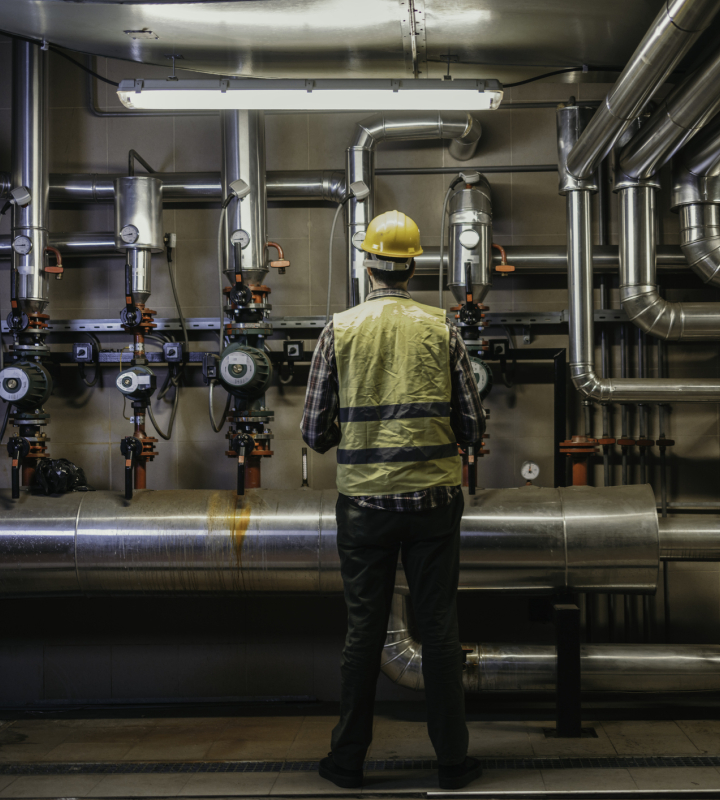 Ein Heizungsinstallateur führt die Wartung einer industriellen Heizungsanlage durch