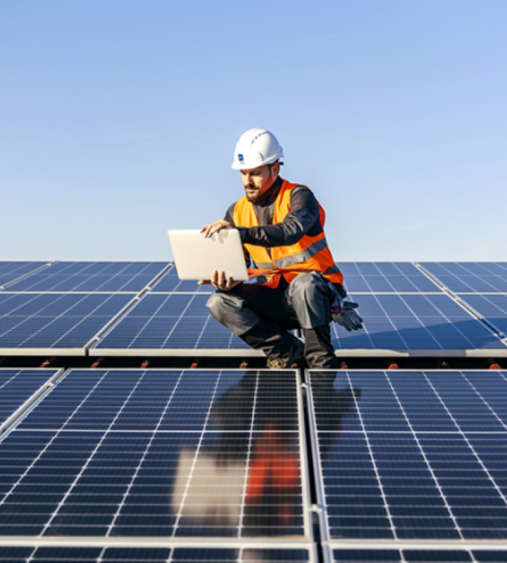 Ein Arbeiter an einer Sonnenkollektoranlage, der diese Dokumente liest