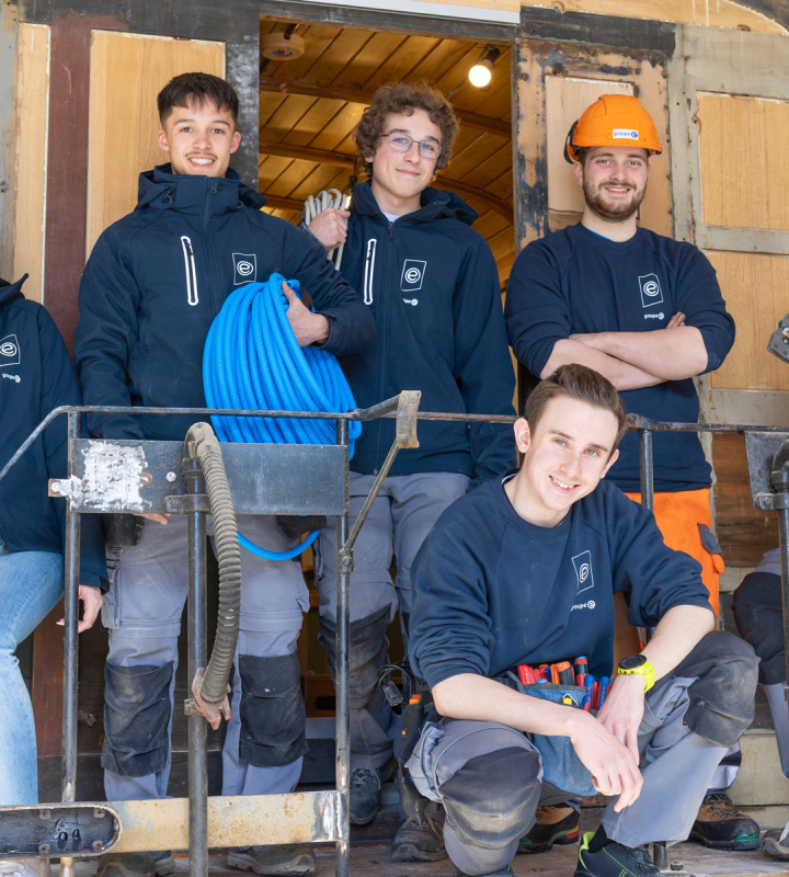 Des apprentis de Groupe E posant devant un wagon GFM qu'ils sont en train de rénover