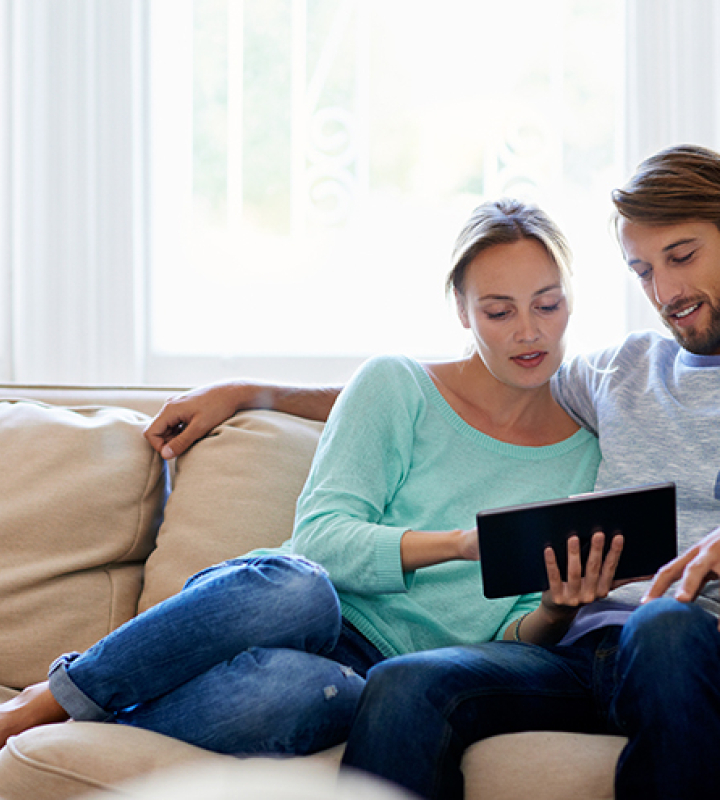 jeune couple qui suit sa consommation grâce au compteur intelligent installé par Groupe E
