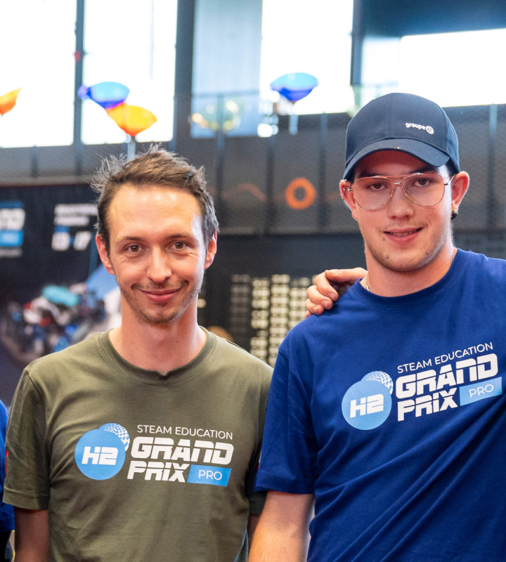 Un groupe de jeunes participants au H2 Grand Prix, un événement éducatif axé sur les technologies de l'hydrogène, posent ensemble pour une photo. Certains portent des casquettes et des t-shirts de Groupe E, montrant leur implication dans la compétition et leur engagement dans les énergies durables et les innovations technologiques.