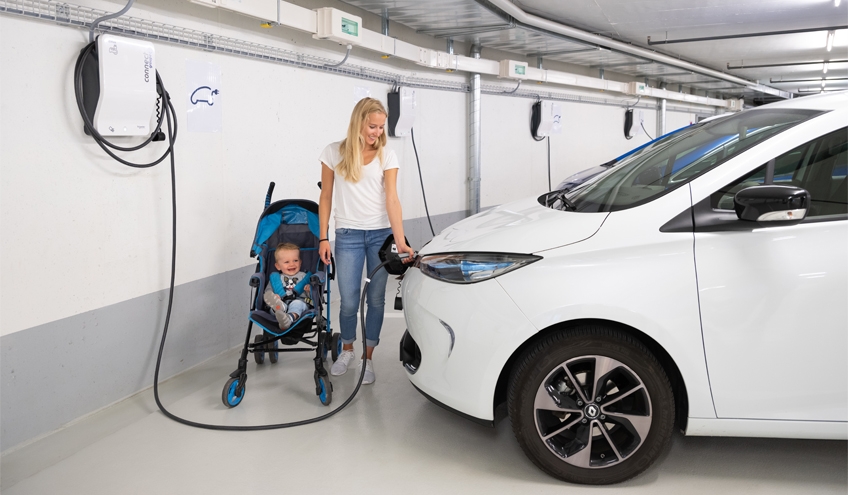 Ein Elektroauto wird dank einer von Groupe E installierten Ladestation auf einem Gebäudeparkplatz aufgeladen