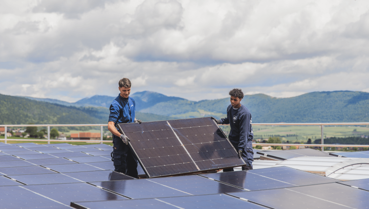 Deux collaborateurs de Groupe E installent des panneaux solaires