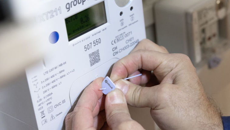 Technicien installe un compteur intelligent de Groupe E.