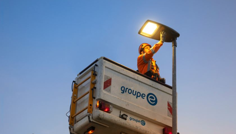 Ein Techniker von Groupe E installiert eine Strassenlaterne.