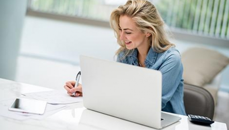 Jeune femme installée devant son ordinateur