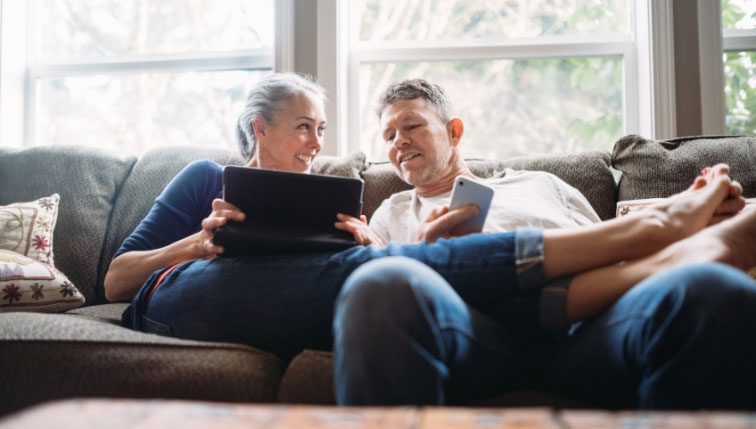 couple heureux qui consulte leur facture du chauffage à distance de Groupe E