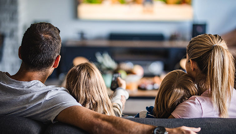 famille heureuse jouissant du confort offert par le raccordement au réseau Groupe E