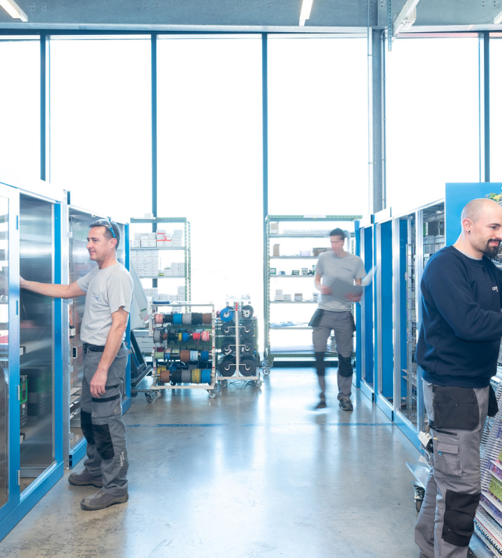 Des collaborateurs de Groupe E assemblent des tableaux électriques dans un atelier spécialisé.