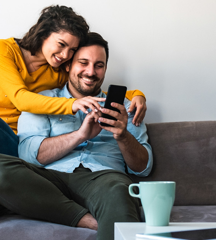 Un couple consulte son taux d'autoconsommation sur un smartphone