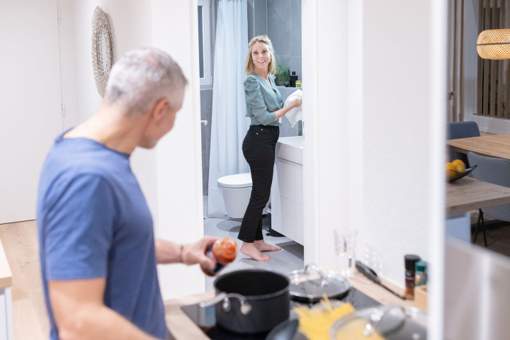 Un couple discute, tout en cuisinant le repas