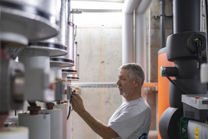 Un collaborateur de Groupe E effectue la maintenance d'une installation CVCS 