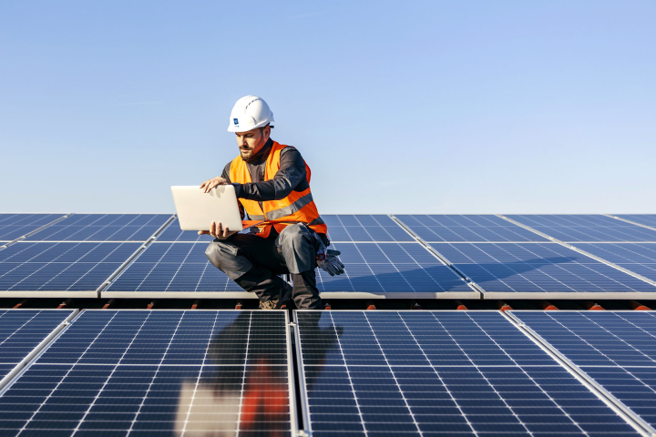 Un collaborateur de Groupe E effectue la maintenance de panneaux solaires