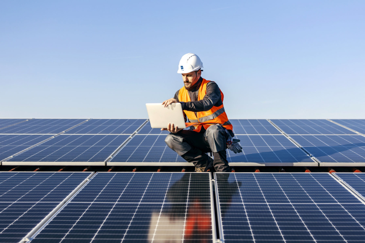 Un collaborateur de Groupe E effectue la maintenance de panneaux solaires