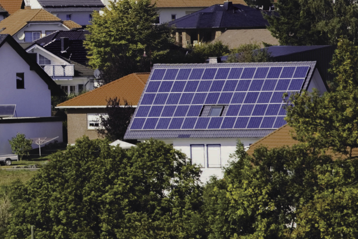 Luftaufnahme von Häusern mit Solarmodulen auf den Dächern, die das Engagement von Groupe E für nachhaltige Solarlösungen für Privatkunden hervorheben