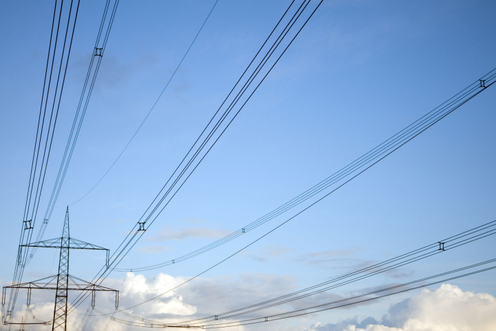 Photo d'une ligne à haute tension, sur fond de ciel bleu