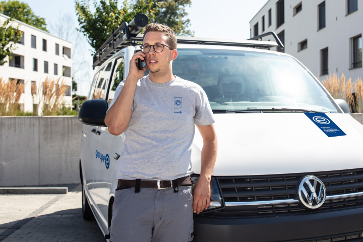 Un dépanneur de Groupe E est en conversation téléphonique avec un client