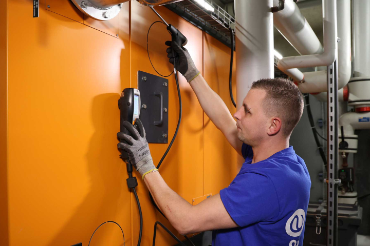 Un collaborateur de Groupe E effectue la maintenance préventive d'une centrale de chauffe