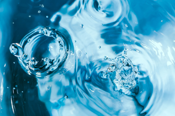 Gouttes d’eau tombant dans une surface d’eau, après avoir été purifiées par un processus d’osmose inverse.