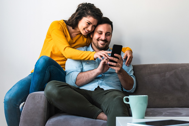 Un couple consulte son taux d'autoconsommation sur un smartphone