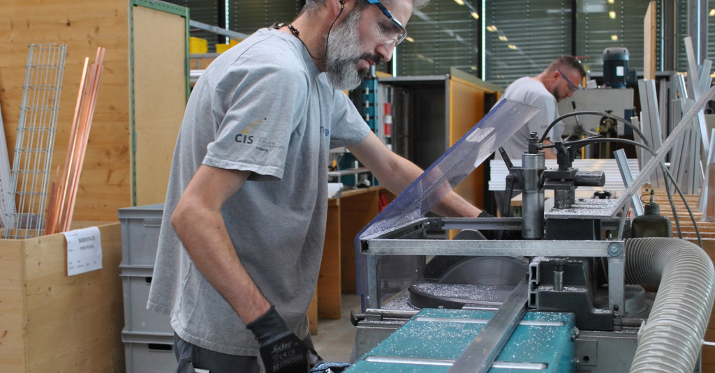 Ein Mitarbeiter des integrierten CIS-Ateliers bearbeitet Holz.