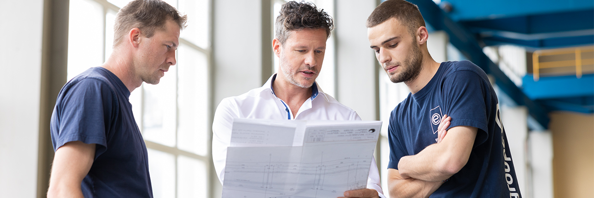 Drei Mitarbeiter der Groupe E tauschen sich über einen Plan aus