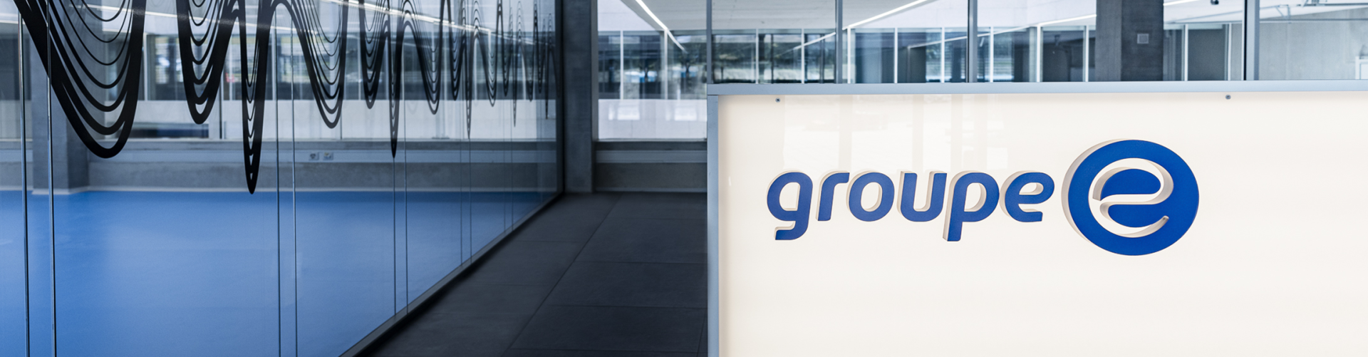 Logo Groupe E sur un mur lumineux